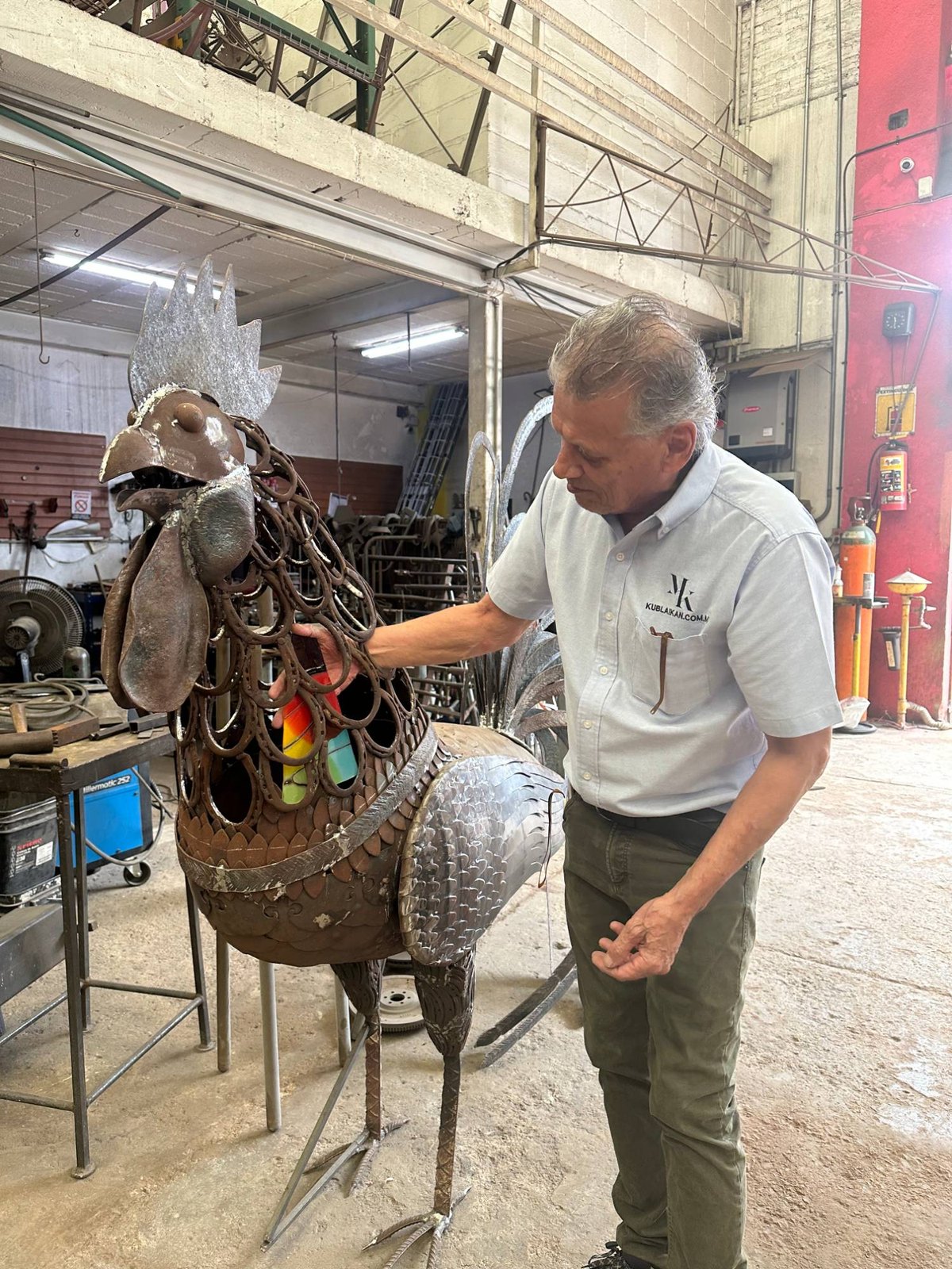 Max Koekkoek con una escultura de gallo de herrería artística y vidrio en el taller de Kublaikan en Tonalá